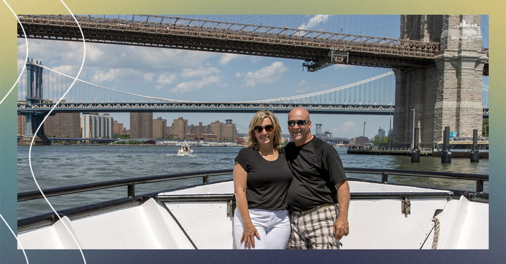 Couple photographed with bridge and city skyline.